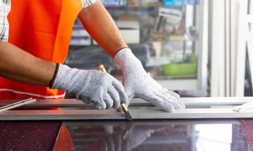 A close up of glass being cut by a hand tools.
