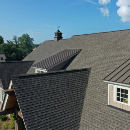 RoofingShingle roofing with metal roofing accents over windows.