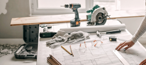 Contractor supplies spread across a table on top of a blueprint.